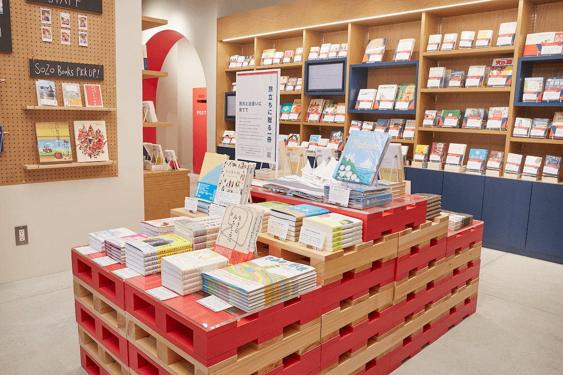 写真：店内にて、積み上げられた書籍と本棚に書籍が並ぶ様子