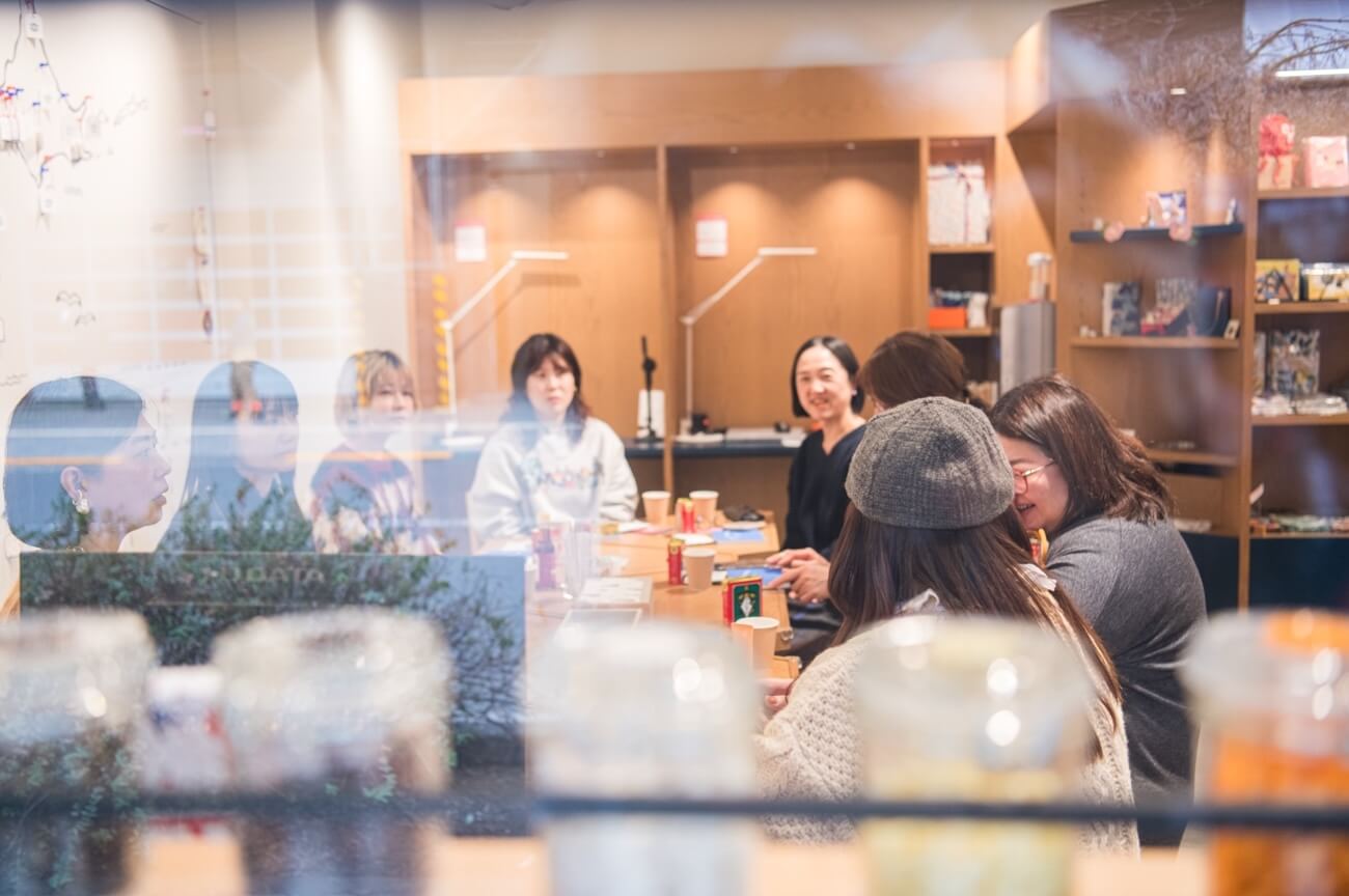 写真:イベントにて参加者がテーブルを囲み、笑いを交えながら話し合う様子