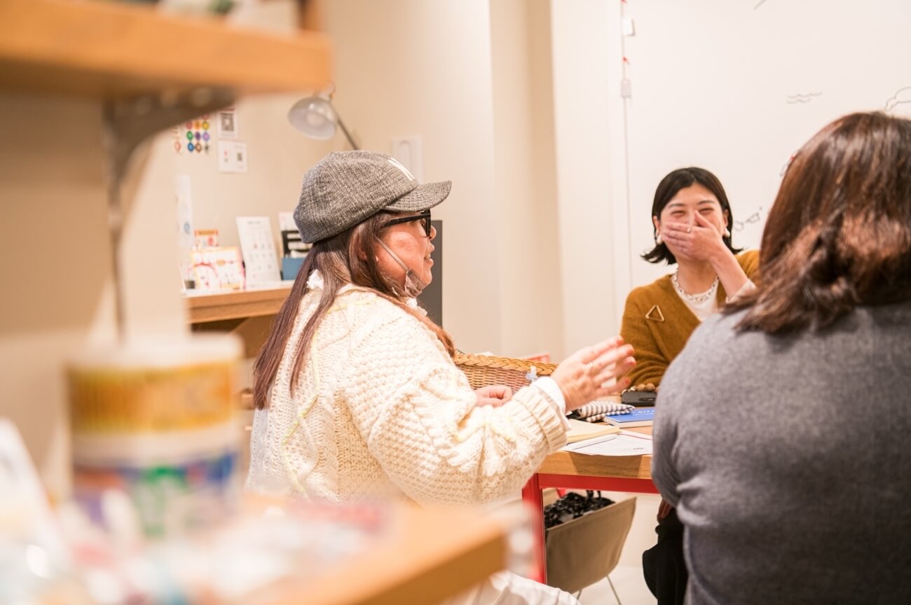 写真:イベントにて参加者がテーブルを囲み、笑いを交えながら話し合う様子
