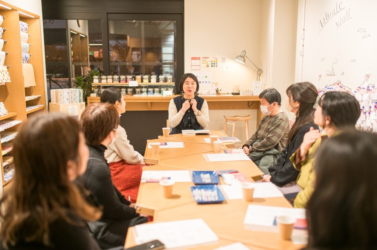 写真:イベントにて参加者がテーブルを囲み説明を聞く様子