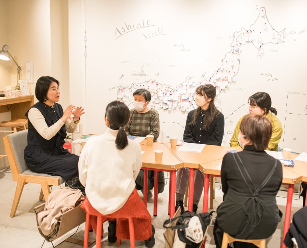 写真:イベントにて参加者がテーブルを囲み説明を聞く様子