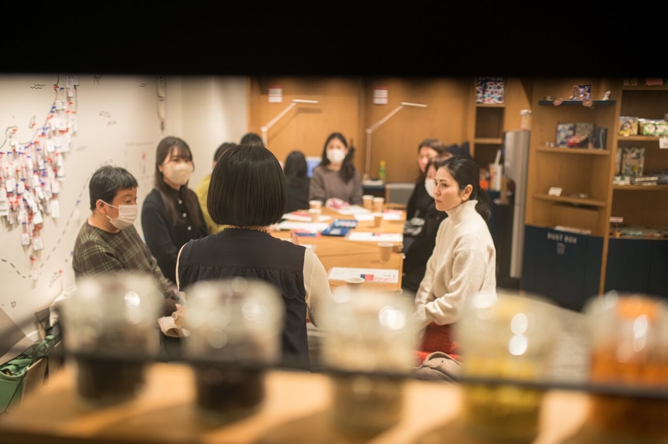 写真:イベントにて参加者がテーブルを囲み説明を聞く様子