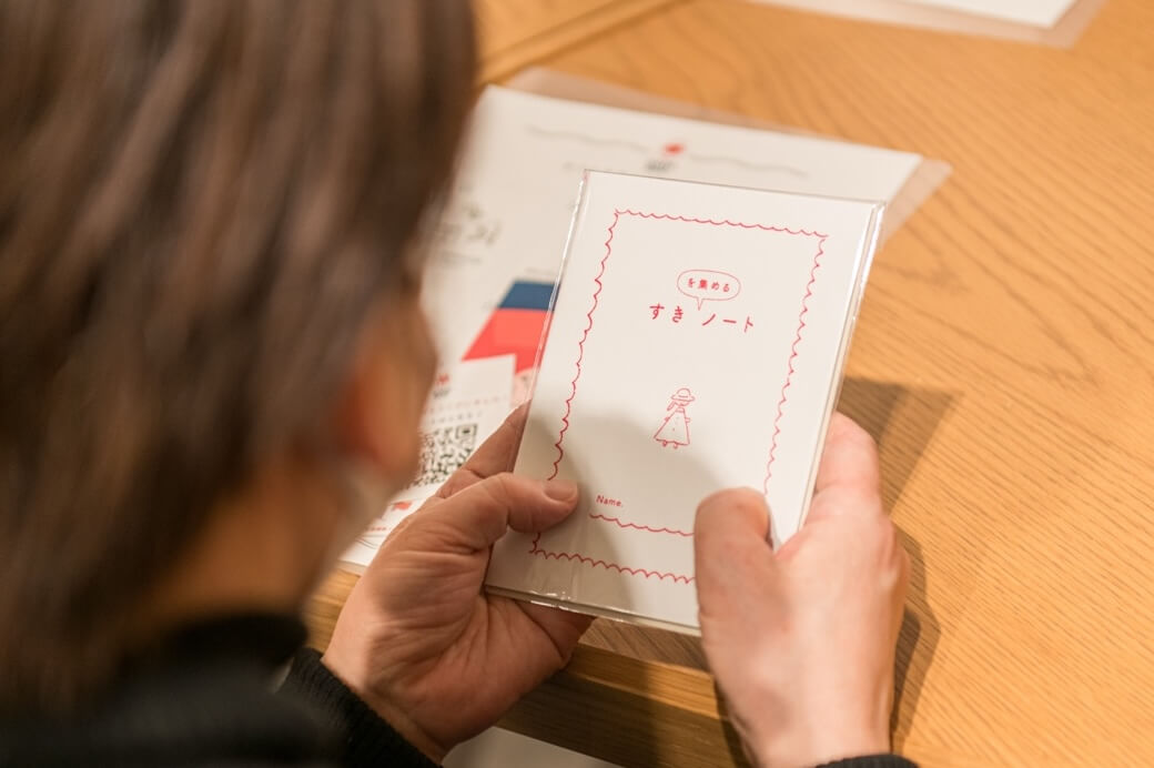 写真:“ギフトすきノート”を手に取る様子