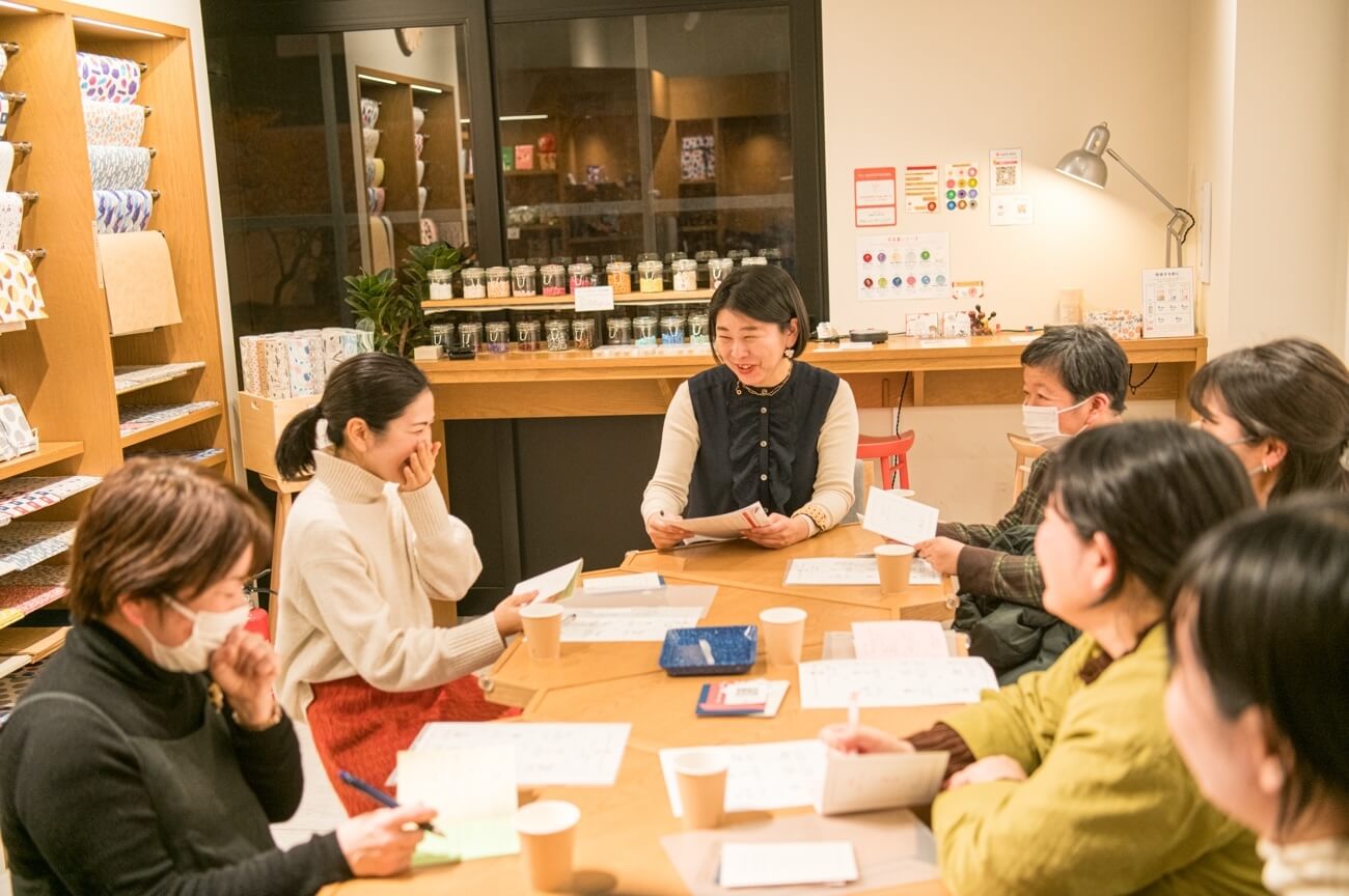 写真:イベントにて参加者がテーブルを囲み、笑いを交えながら話し合う様子