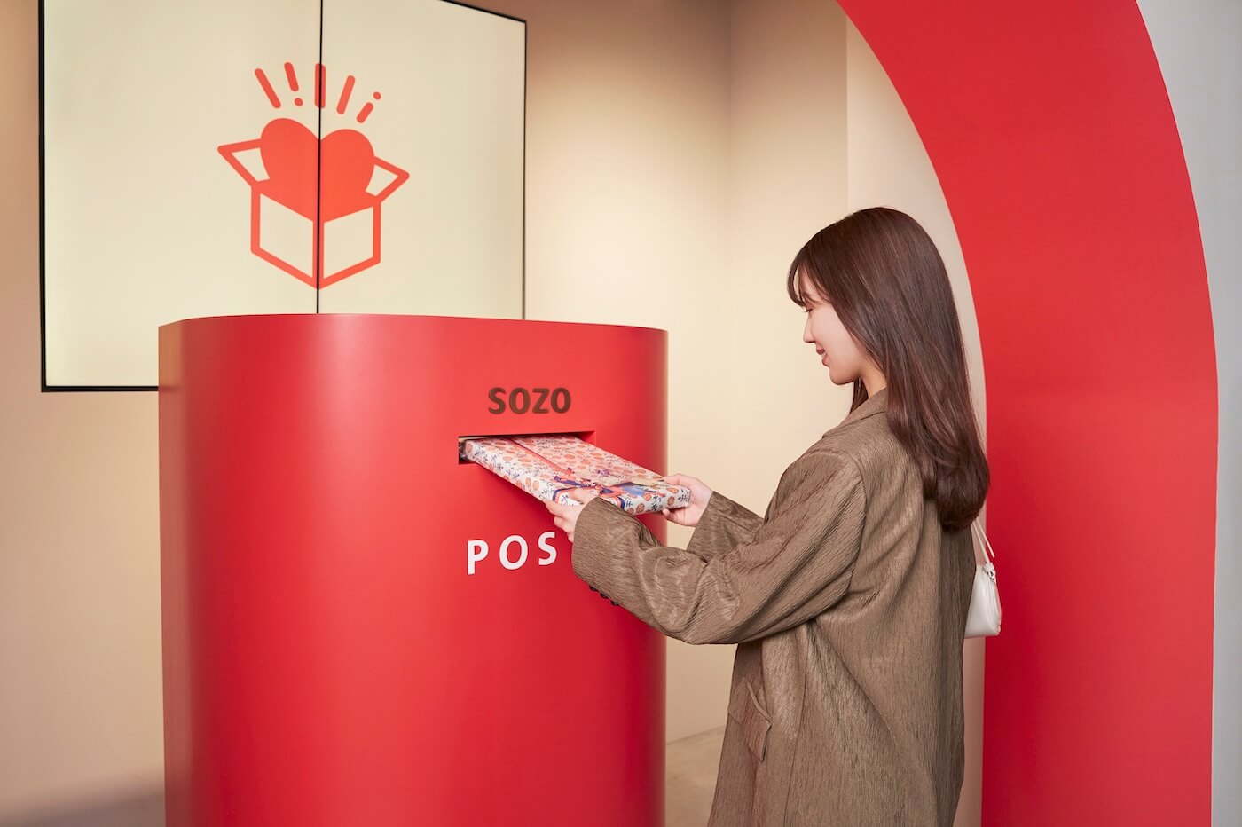 写真：店舗内のＳＯＺＯ　ＰＯＳＴに投函する様子